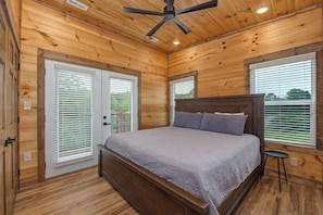 A bedroom with a wooden ceiling, a bed with a headboard, and a ceiling fan. - Relaxing 5BD POOL Lodge| Theater + Hot Tub + Games (Sevierville)