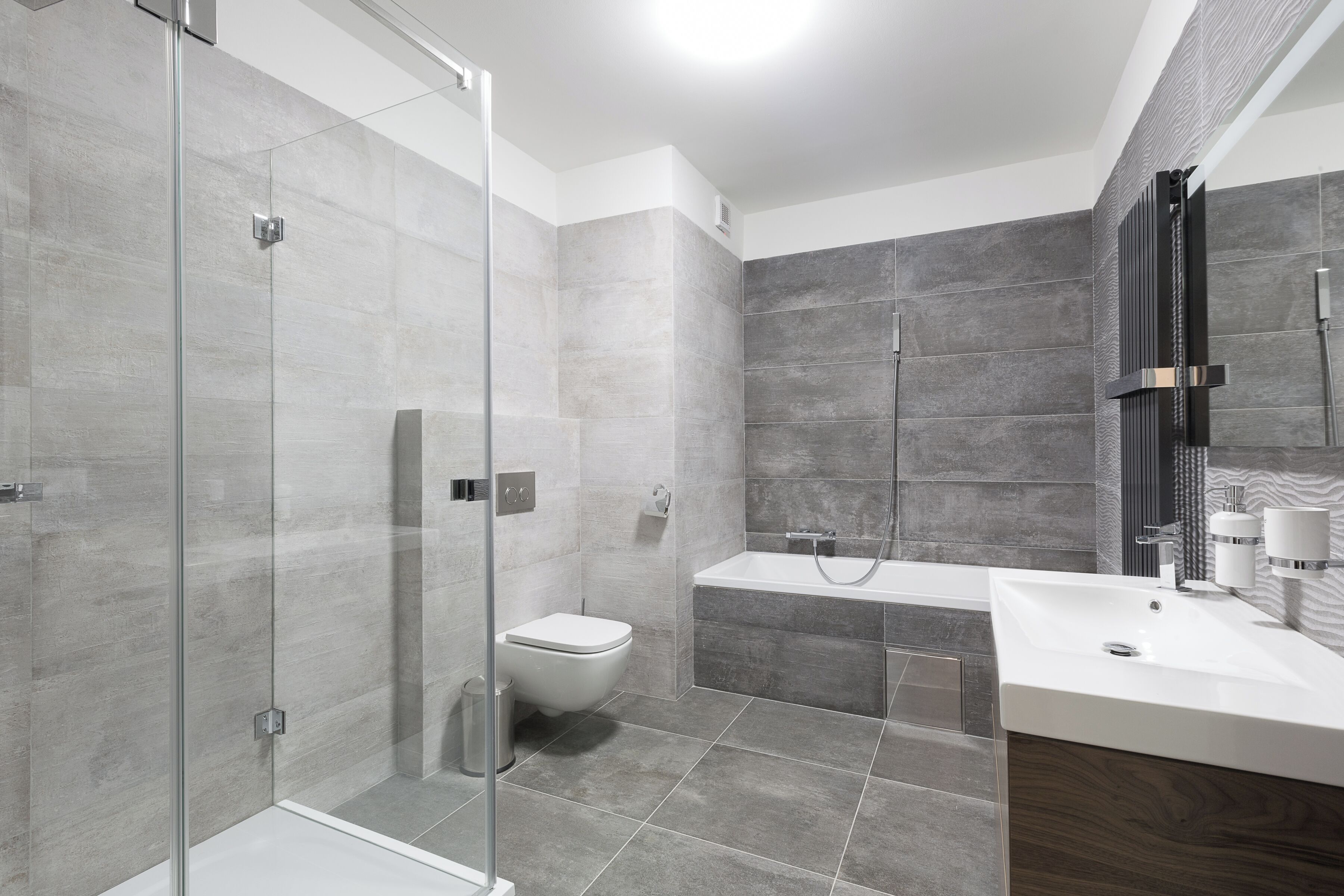 Un baño moderno con cabina de ducha de vidrio, bañera y lavamanos blanco.