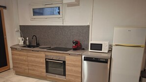 A modern kitchen with a built-in oven, microwave, and dishwasher. - Le Cocon St Martin – Cozy Duplex in Nevers City Center, Air Conditioning (Nevers)