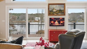 Sala de estar com uma janela grande, um armário vermelho e uma TV na parede.