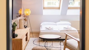Une chambre moderne avec une lucarne, un lit, une table ronde et une chaise.