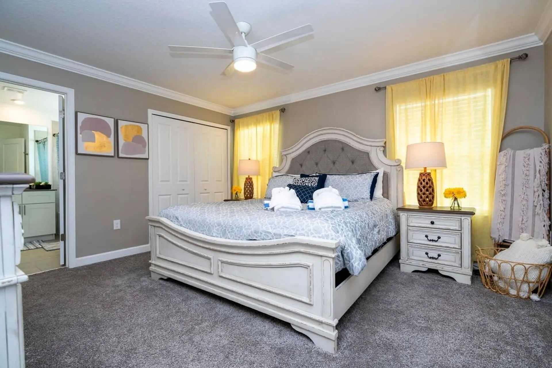 A bedroom with a bed, bedside tables, a ceiling fan, and a wardrobe.