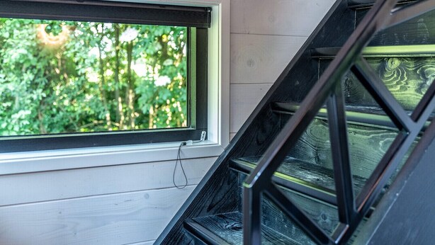 Een houten interieur met uitzicht op groen.