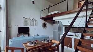 A modern living space with a dining area, a sofa, a TV, and a staircase. - Two bedroom  in Mexico, Tulum (Tulum)