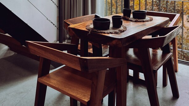 A wooden dining table with chairs, two black mugs, and a woven placemat. - Two bedroom  in Mexico, Tulum (Tulum)