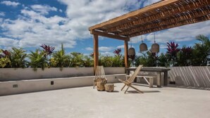 An outdoor patio with a wooden pergola, a lounge chair, and a table. - Two bedroom  in Mexico, Tulum (Tulum)