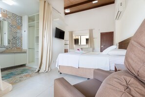 Ein Schlafzimmer mit Bett, Fernseher, Kleiderschrank und Bad.