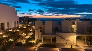 A modern building complex with multiple levels, outdoor staircases, and well-lit pathways. - Playa Paraiso Beachfront Apartment (La Vila Joiosa)