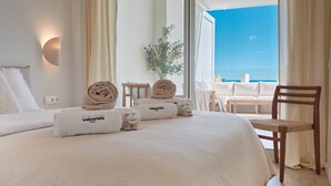 A hotel room with a bed, a chair, and a view of the ocean. - Playa Paraiso Beachfront Apartment (La Vila Joiosa)