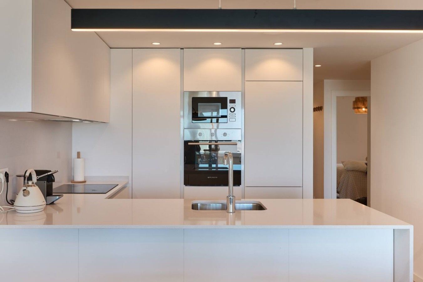 Eine moderne Küche mit einer zentralen Kochinsel, integrierten Geräten und einem eleganten Design.