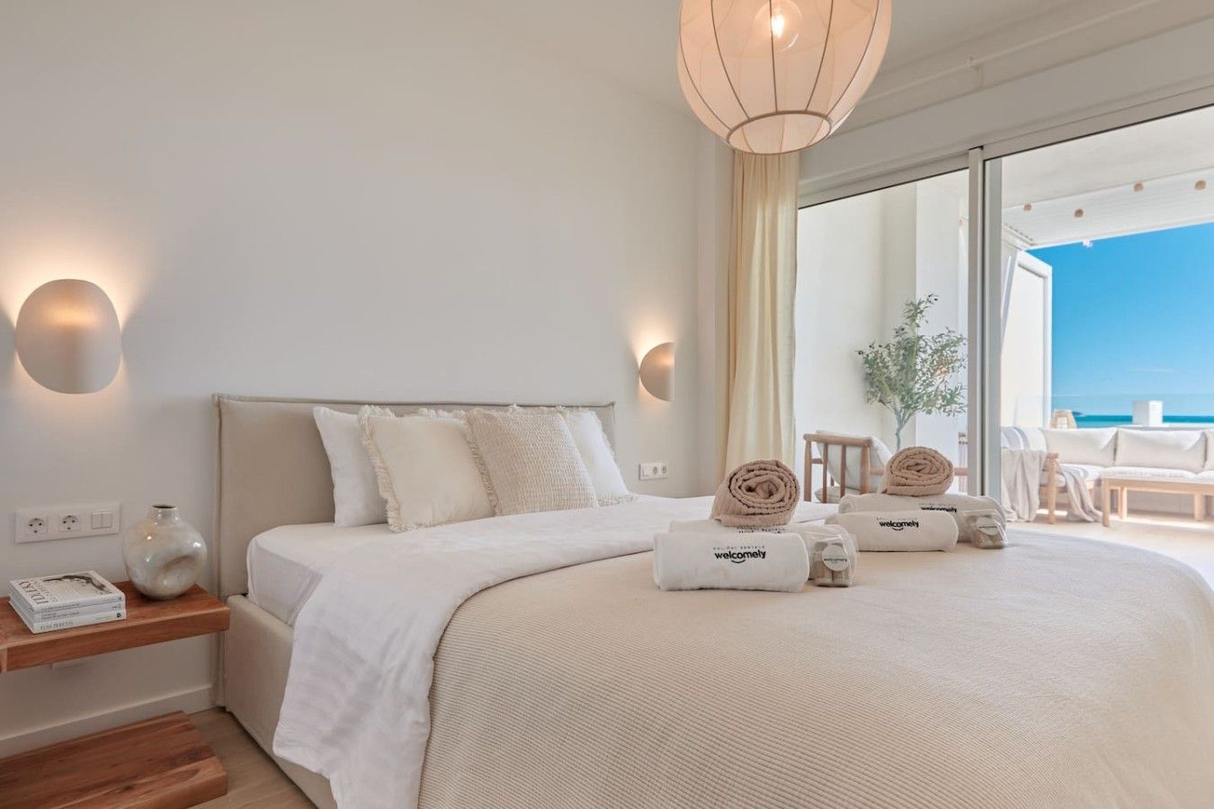 Ein Hotelzimmer mit Bett, Nachttischen und Meerblick.