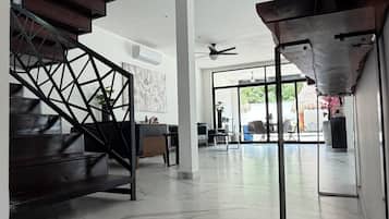 A modern interior with a spiral staircase, a seating area, and a view through large glass doors.