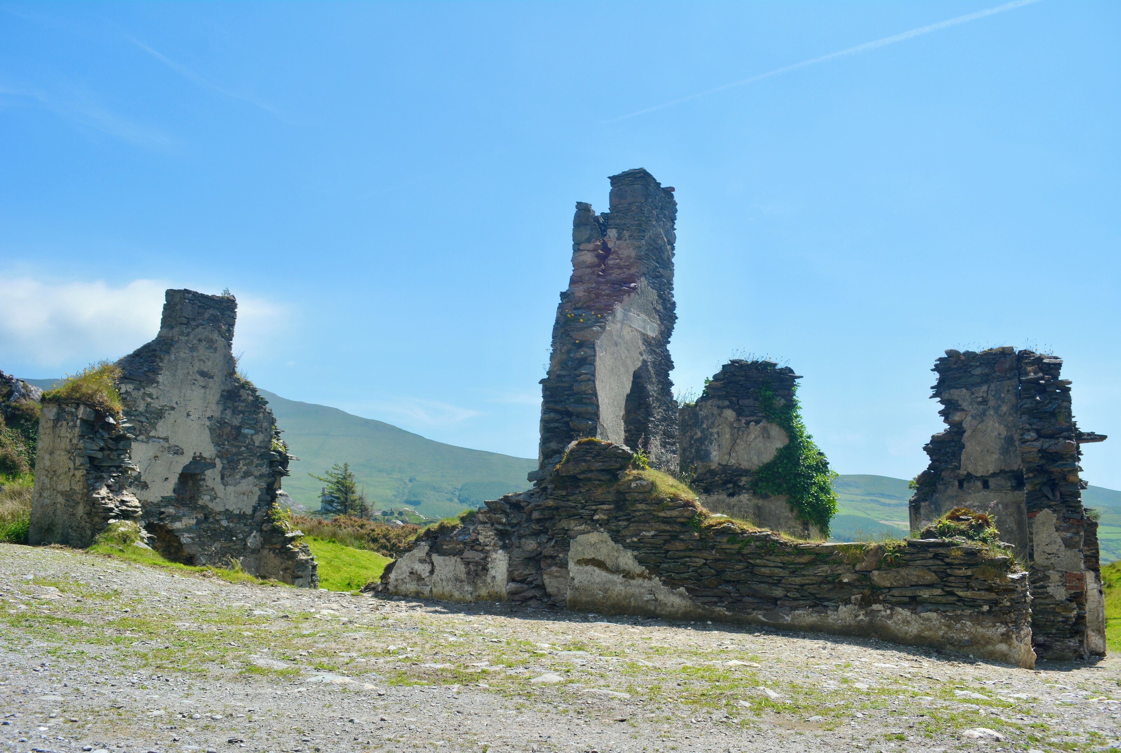 Ancient stone ruins with a clear sky and distant hills.