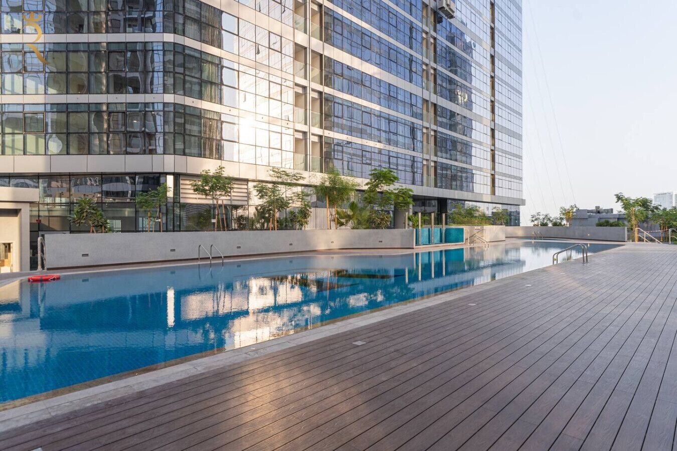 A modern building with a swimming pool and wooden deck.