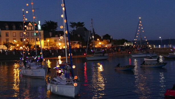 A harbor at dusk with boats docked and illuminated by string lights. - 50m beach balcony facing the sea 2P duplex 31 m2 for 2 adults + 2 children, (LOCQUIREC)