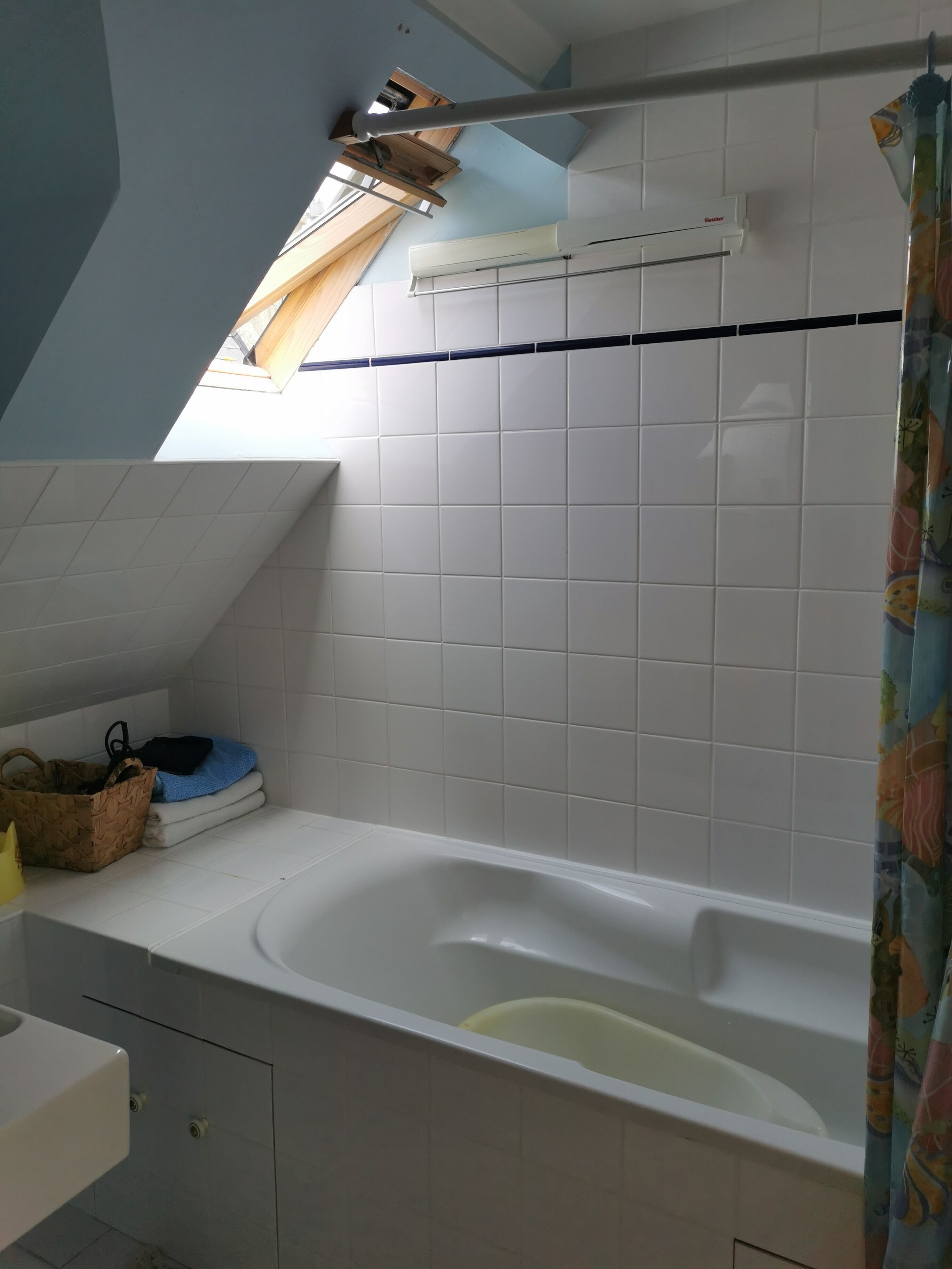 Une salle de bain avec une baignoire, un ventilateur de plafond et une fenêtre.