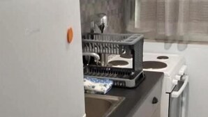 Eine kleine Küche mit Kühlschrank, Herd und Spüle.