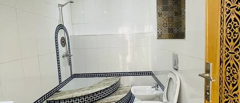 Un baño con inodoro, bidé y ducha.