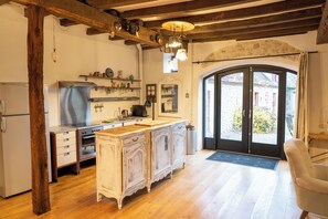 A kitchen with wooden cabinets, a built-in oven, and a large window. - House 3 on the Embourg estate (Souvigny)