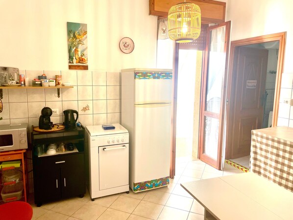 A compact kitchen with a microwave, coffee maker, and a small refrigerator.