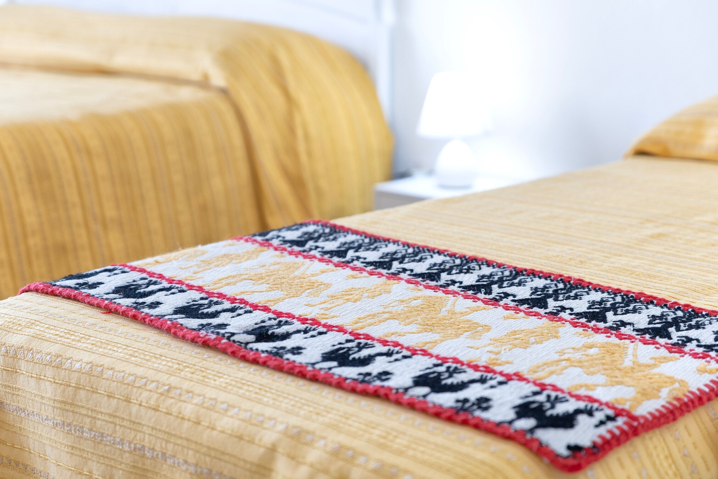 Un lit avec une couvre-lit à motifs et une bordure décorative.