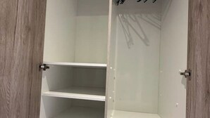 Een kamer met een houten deur en een witte inrichting.