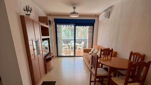 Une cuisine spacieuse avec un coin repas, une porte-fenêtre coulissante donnant sur un balcon et un ventilateur de plafond.