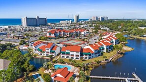 Ein Küstenhotel mit mehreren Gebäuden, einer Marina und einem Schwimmbad.