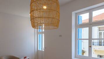 Une chambre à coucher comprenant un lit, une chaise, une petite table et un luminaire suspendu.
