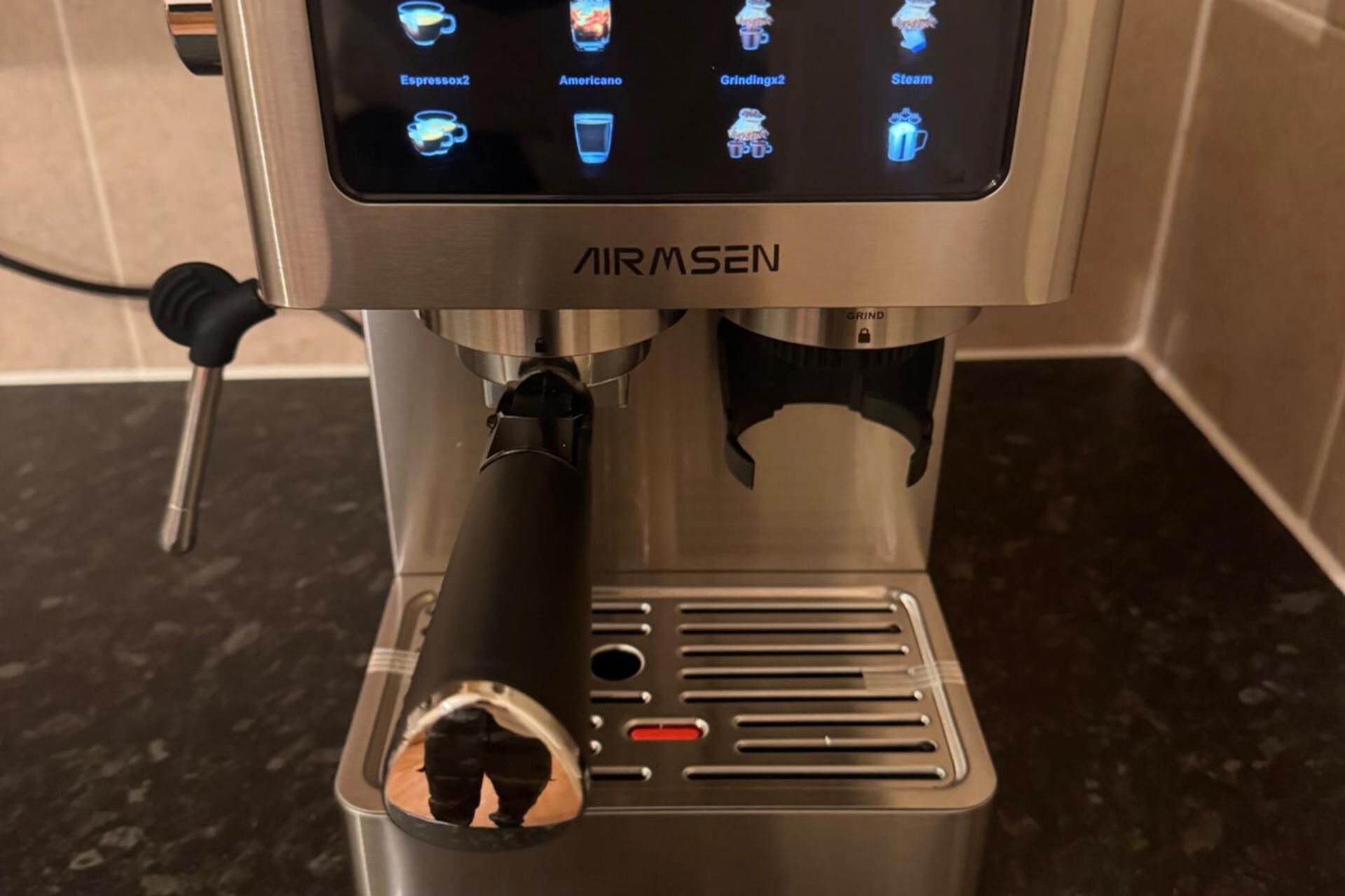 Une machine à café dotée d’un écran numérique et d’un accessoire pour moudre les grains.