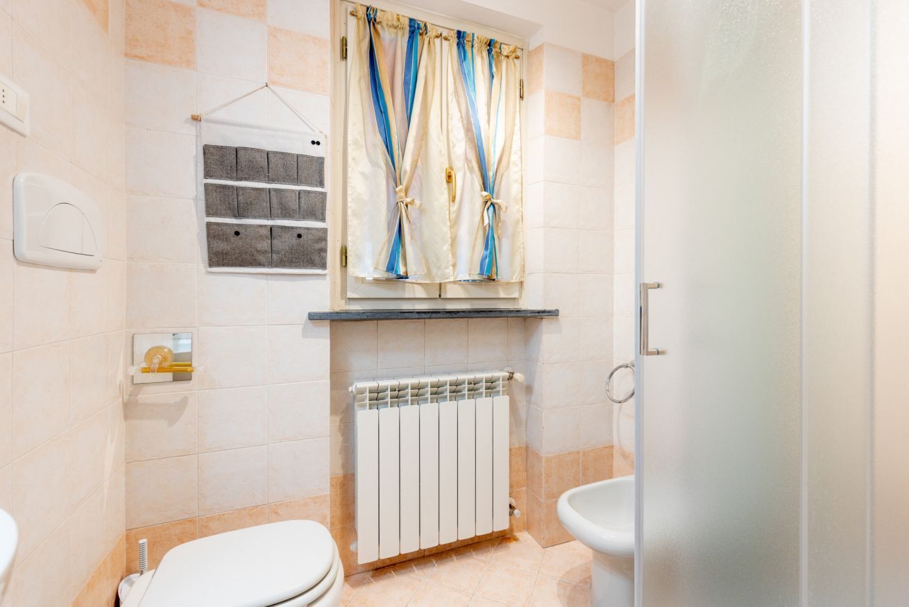 A bathroom with a toilet, bidet, and a radiator.