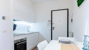 A compact kitchen with a built-in oven, a sink, and a dining area with a table and chairs. - GuestHost - Cozy 50m2 attic apartment, ideal for 4 people, located on the first floor of a building without a lift (stairs to access it).The accommodation is located a stone's throw from the center of Lucca, a historic city that boasts symbolic places su (Lucca)
