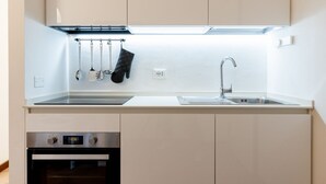 A kitchen with a built-in oven, a sink, and hanging utensils. - GuestHost - Cozy 50m2 attic apartment, ideal for 4 people, located on the first floor of a building without a lift (stairs to access it).The accommodation is located a stone's throw from the center of Lucca, a historic city that boasts symbolic places su (Lucca)