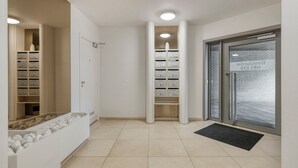 Un corridoio pulito e moderno con armadietti, una reception e una porta in vetro con un cartello.