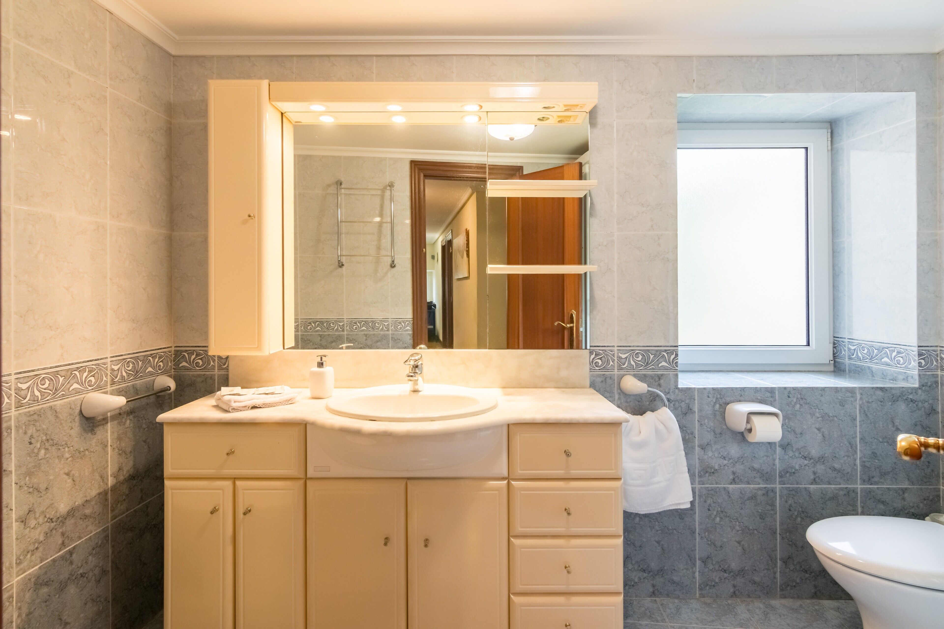 A bathroom with a sink, mirror, and toilet.