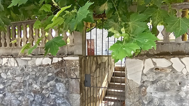 A stone wall with a metal gate leading to a staircase. - La Casona de Ilusión (Solórzano)