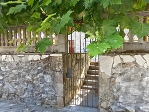 Un muro de piedra con una reja metálica que da a una escalera.