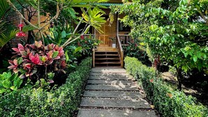 Un sendero de jardín que lleva a una estructura de madera con una escalera.