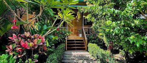 A garden pathway leading to a wooden structure with a staircase.