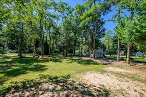 A campground with picnic tables, a swing set, and a small building.