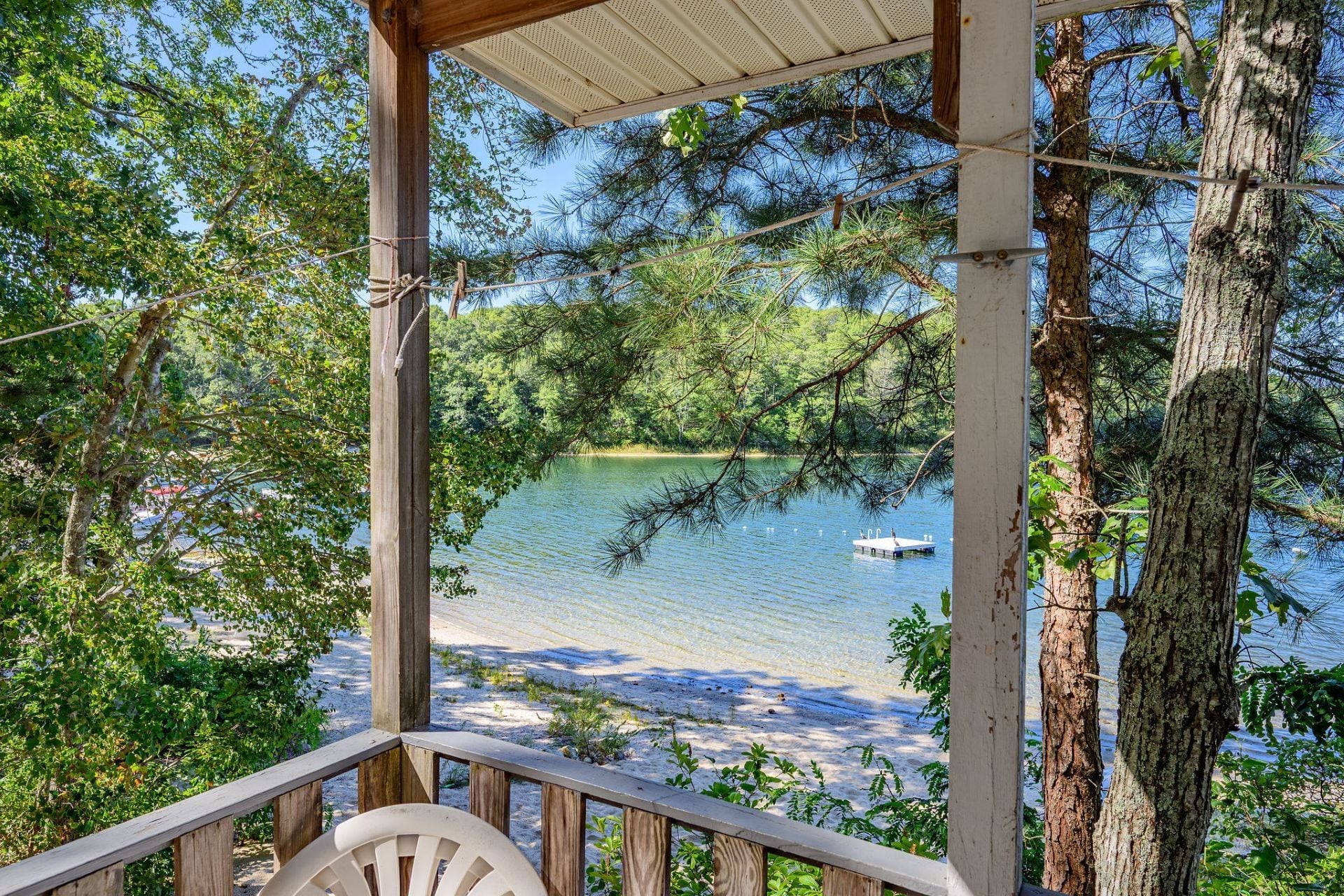 A wooden deck with a view of a lake and a boat.