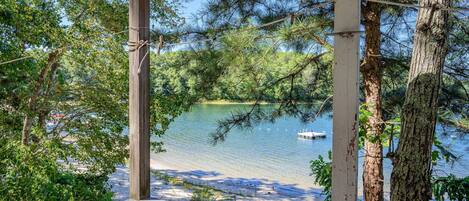 A wooden deck with a view of a lake and a boat.