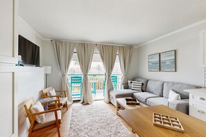 TV, books - Centrally located, cozy condo with shared pool & hot tub - steps to sand (Galveston)