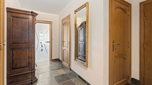 A hallway with wooden doors and a mirror on the wall.