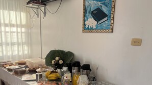 A buffet table with various food items and a television mounted on the wall.