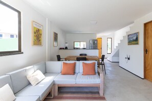 Ein modernes Interieur mit einer Couch, einem Esstisch und einer Küchenzeile.
