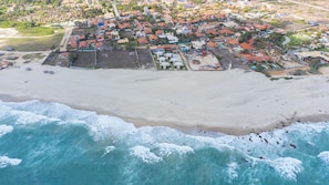 An aerial view of a coastal town with a sandy beach and ocean waves. - Beachfront Duplex #A6 - Aquiraz By Carpediem (Aquiraz)