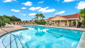 A swimming pool with lounge chairs and a covered seating area. - Family Getaway Near Disney - 3BR and Pool Access (Kissimmee)