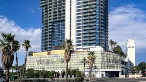 Ein hohes, modernes Hotel mit mehreren Stockwerken und einer auffälligen 'PALMS'-Beschilderung, das ein Balkongitter und eine Glasfassade aufweist.