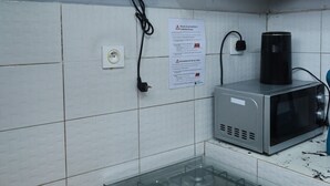 Una cucina con piano cottura a gas, forno a microonde e cappa aspirante blu.